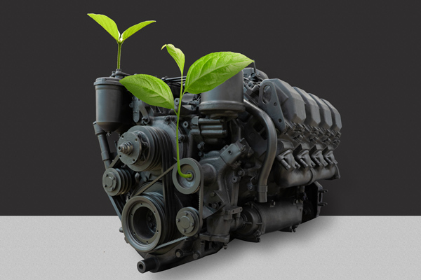 an old diesel engine with green plants growing from it