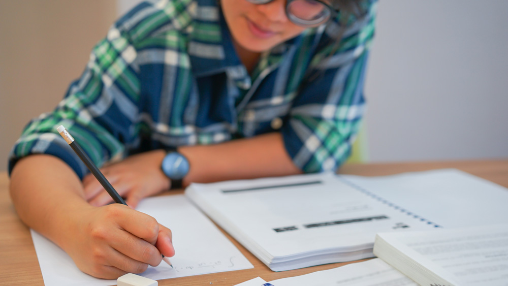 student does homework at table